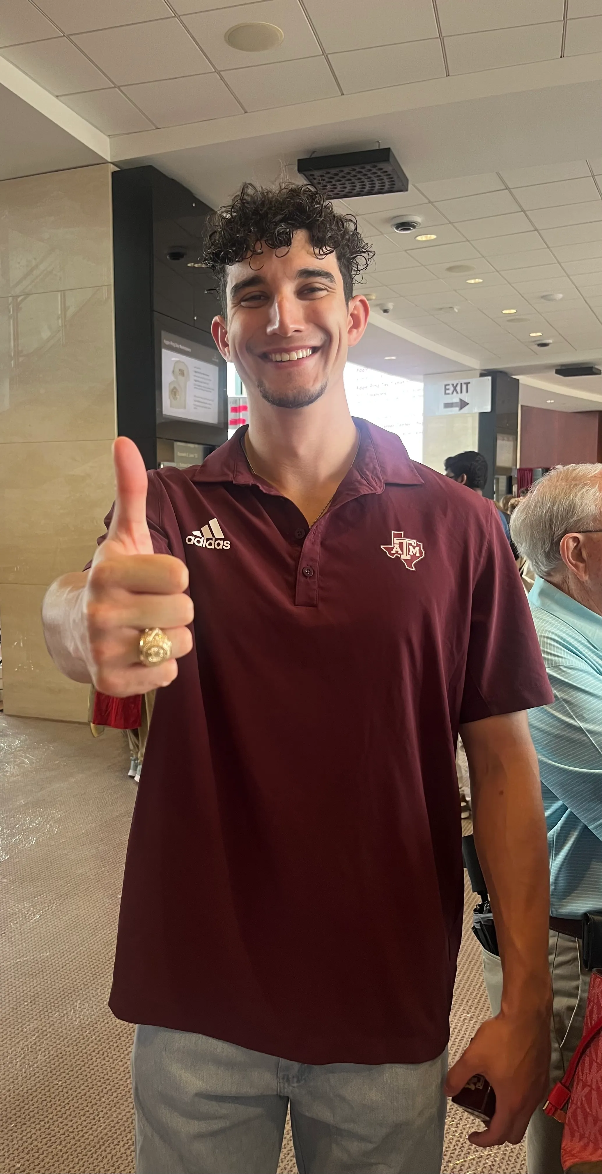 James Londrigan wearing his Texas A&M Aggie ring, making the Gig 'em hand signal